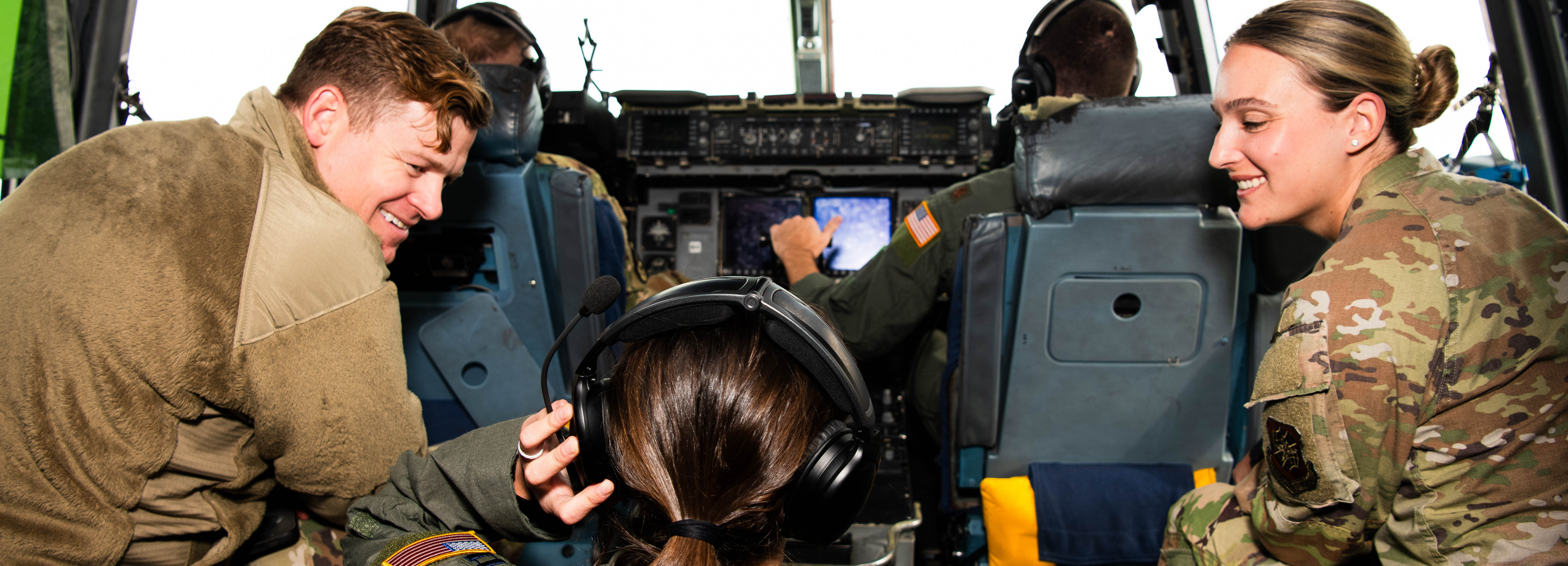 A photo of service members conversing inside the cockpit of a C-17 Globemaster III.